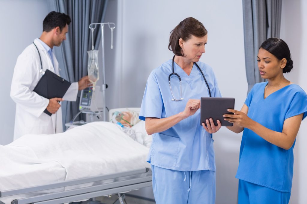Doctor and nurse discussing over digital tablet